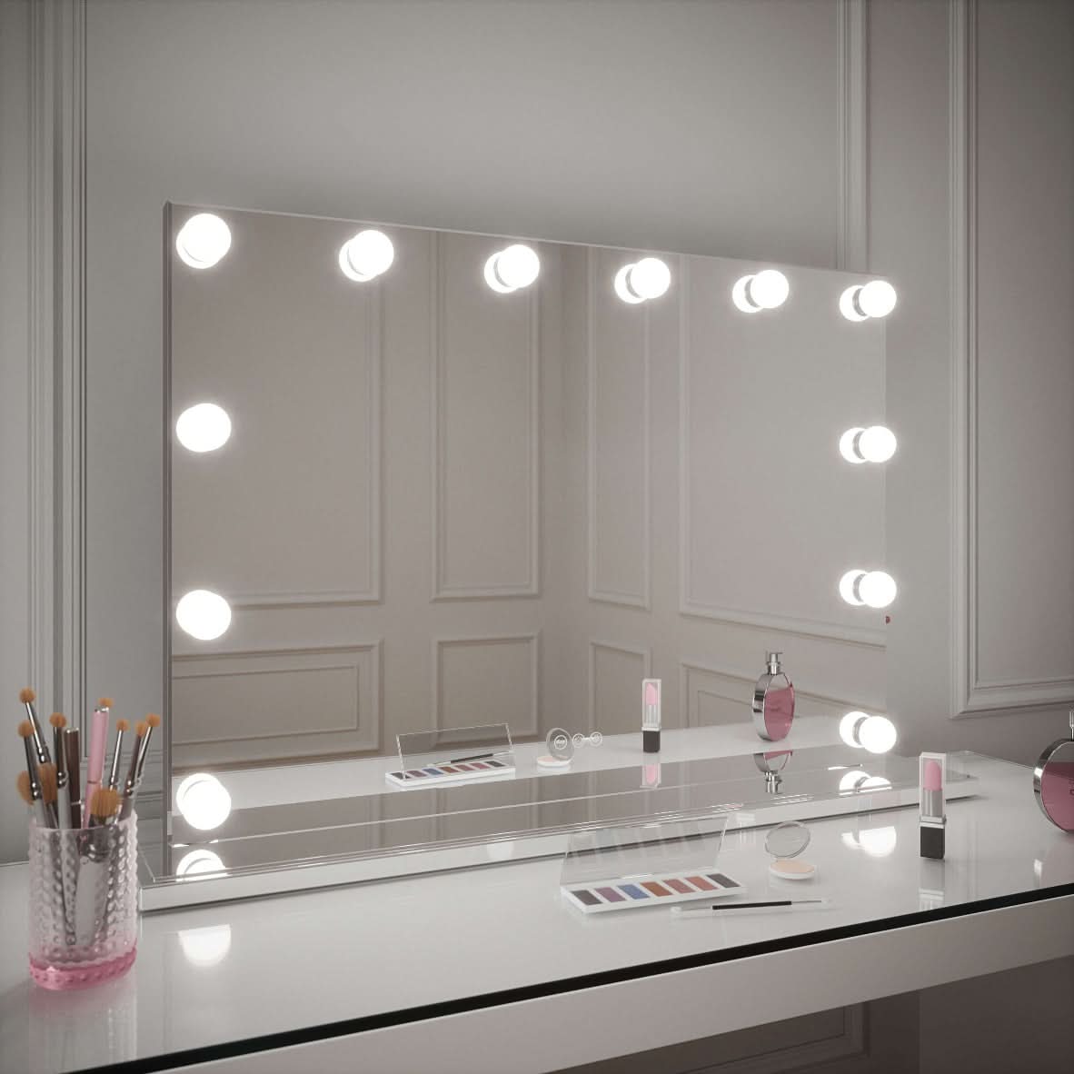 The Scarlett Large Hollywood Mirror 100x70cm by hollywood mirrors shines on a white vanity with makeup brushes, cosmetics, and accessories neatly arranged in front, set against elegant paneled walls.